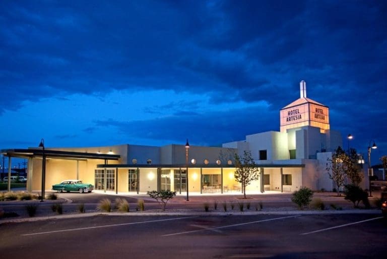 Hotel Artesia illuminated at dusk with a vintage car. Our Digital Marketing Company can promote your business effectively.
