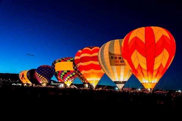 Row of colorful hot air balloons in North Valley, New Mexico, at dusk. Our SEO Company can drive traffic to your website.