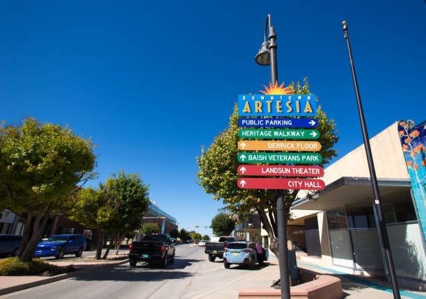 Directional sign in Artesia, New Mexico, under a blue sky. A Web Development Company can help build your online platform.