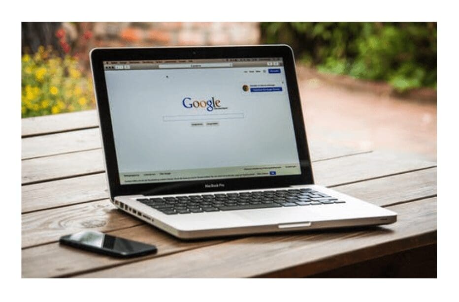 A close-up of a phone and laptop screen with Google