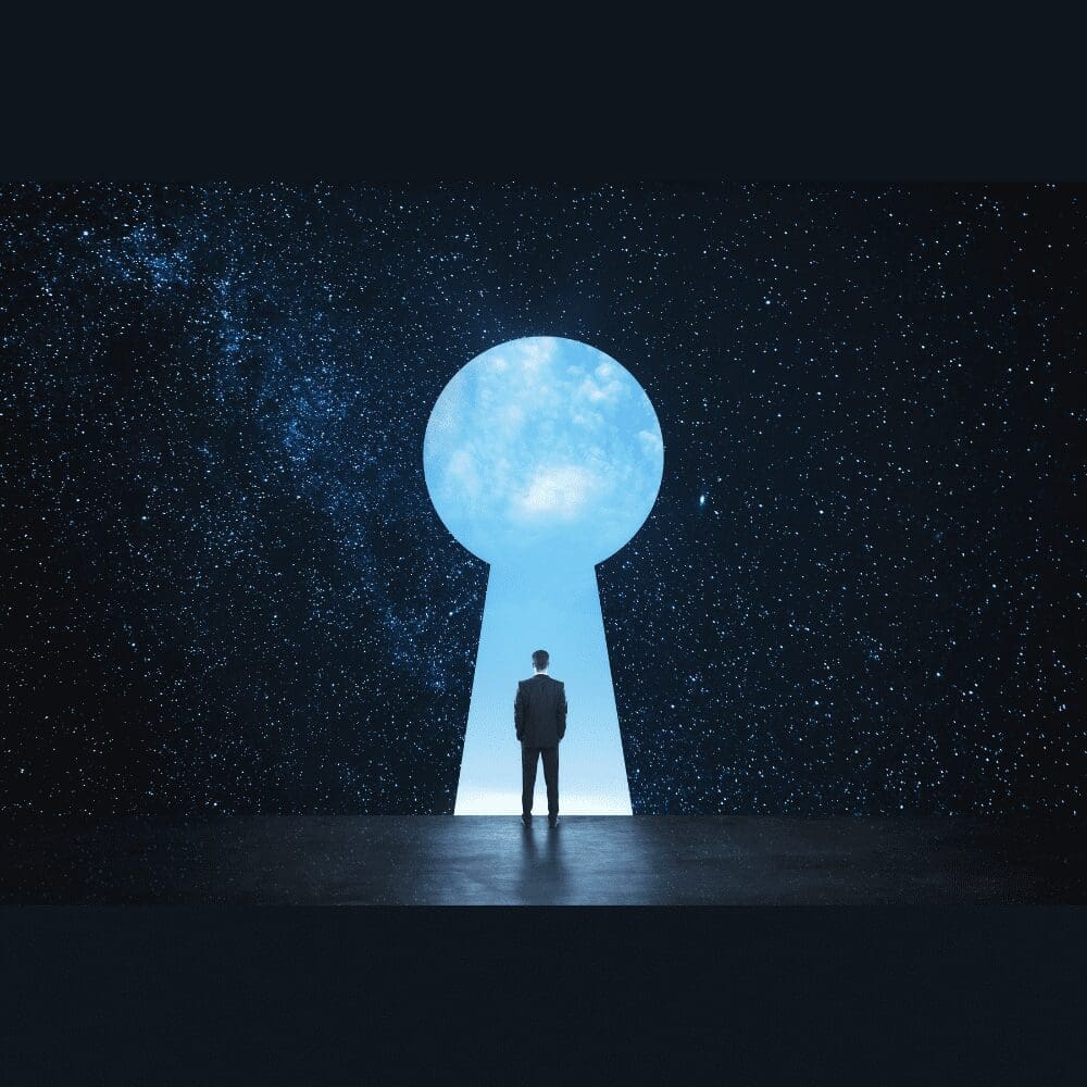 large dark room with a giant keyhole leading out to a clear blue sky. Man standing in the keyhole doorway