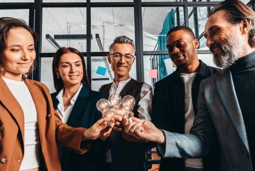 team members all holding glowing lightbulbs